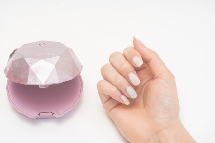 LEDライトとネイルをした女性の手