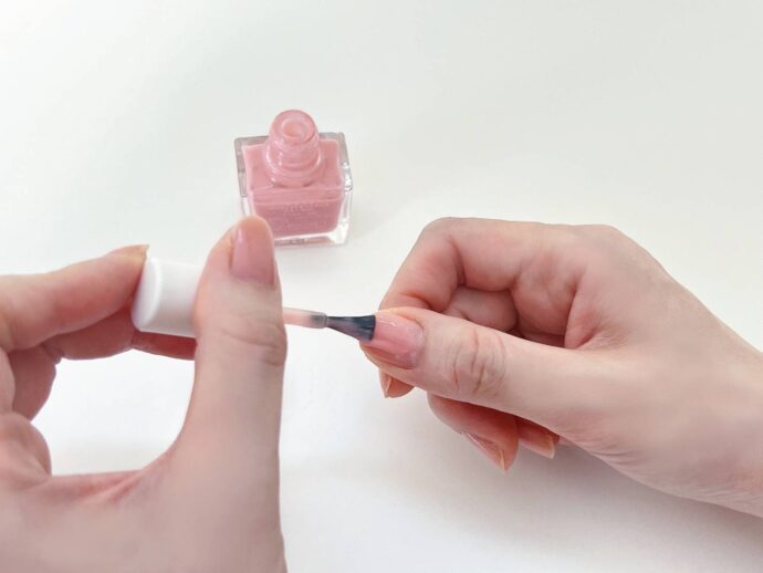 ナチュラルなくすみピンクのマニキュアを塗っている様子