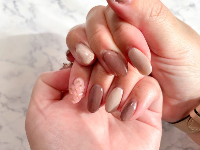 ピンクのキルティングネイルをした手