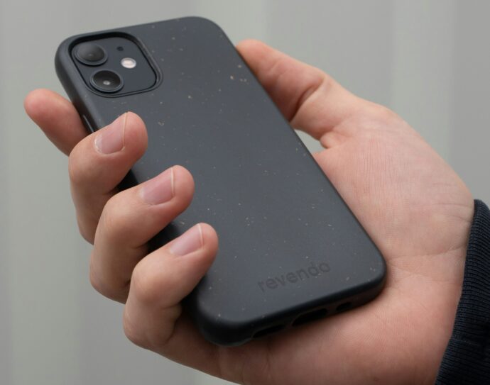 ケアされた爪でスマホを持つ手