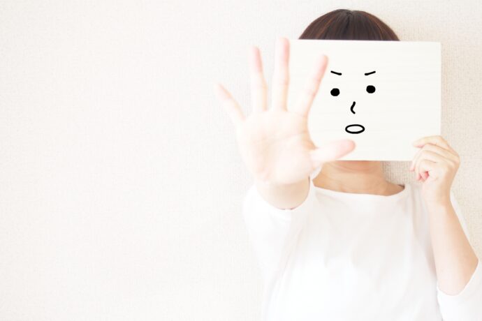 お面をつけて気をつけるように促す女性