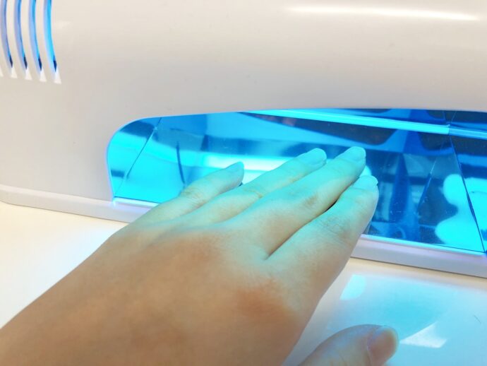 ネイルのUVライトに手を入れる様子