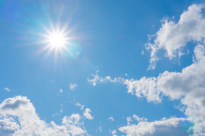 青い空に雲と太陽が照らす様子