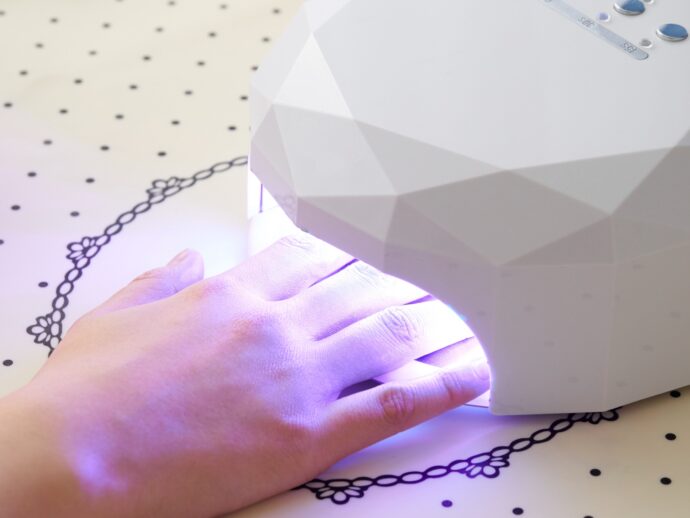 ジェルネイルのライトに手を入れて硬化中