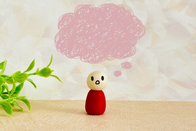 考え事をしている様子の人形