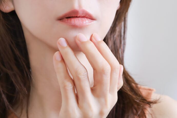 口元に手を置いて考えている様子