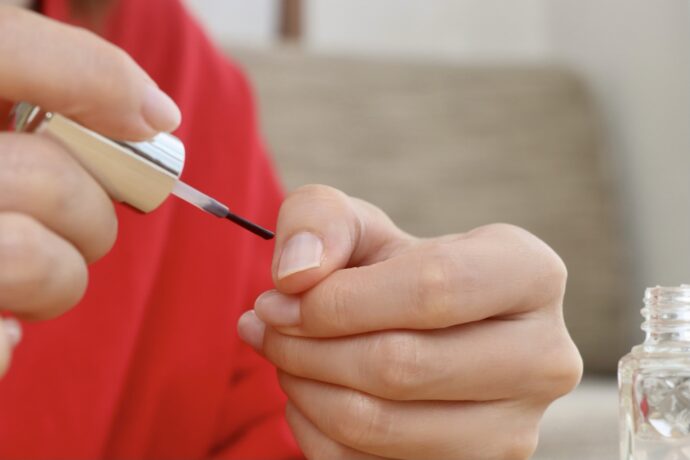 爪にキューティクルリムーバーを塗る様子