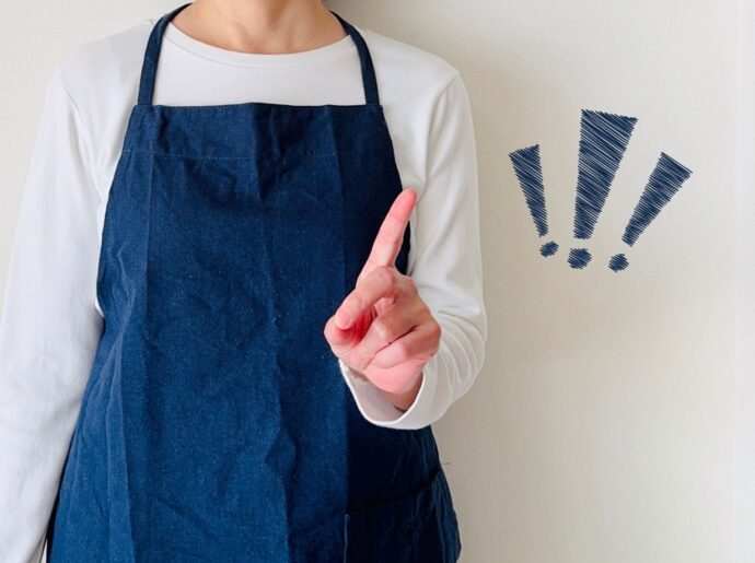 ポイントをするエプロン姿の女性