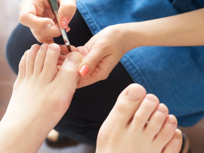 フットネイル施術中のネイリストの手元のアップ