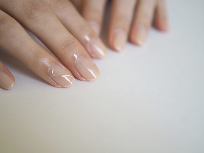 クリア×ゴールドラインのネイルをした手