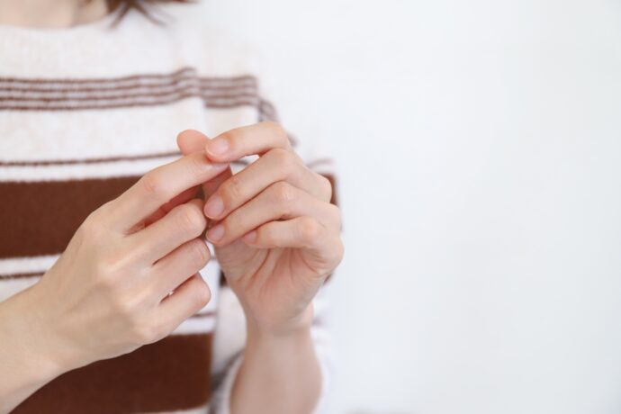 爪を気にする女性の手元