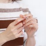 爪を気にする女性の手元