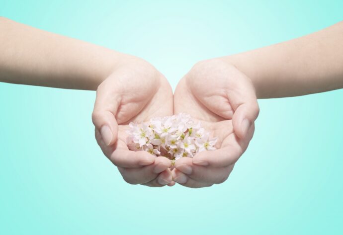 両手の平の上に小花を乗せた様子