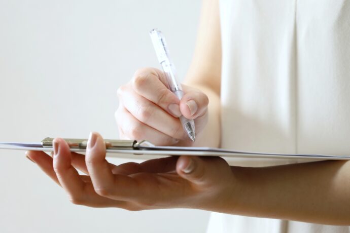 カルテを書いているネイリストの手元